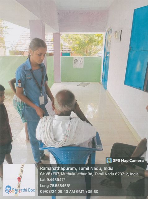 Health worker assisting an elderly patient at the camp