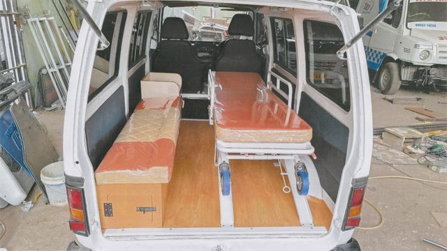 Rear view of an ambulance being fitted with a stretcher